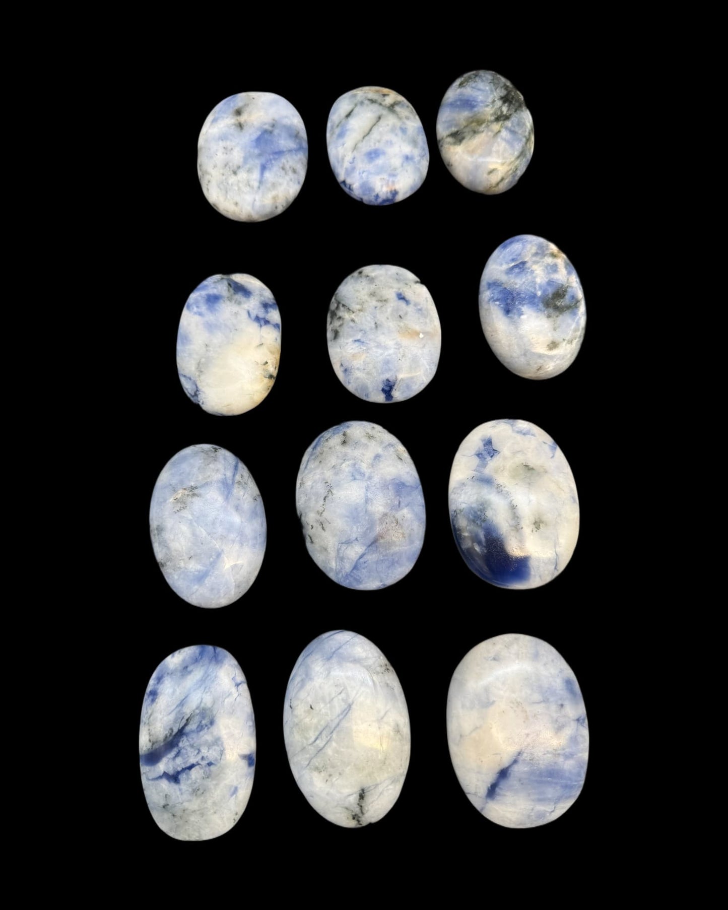 mehrere Sodalit Handschmeichler vor schwarzem Hintergrund