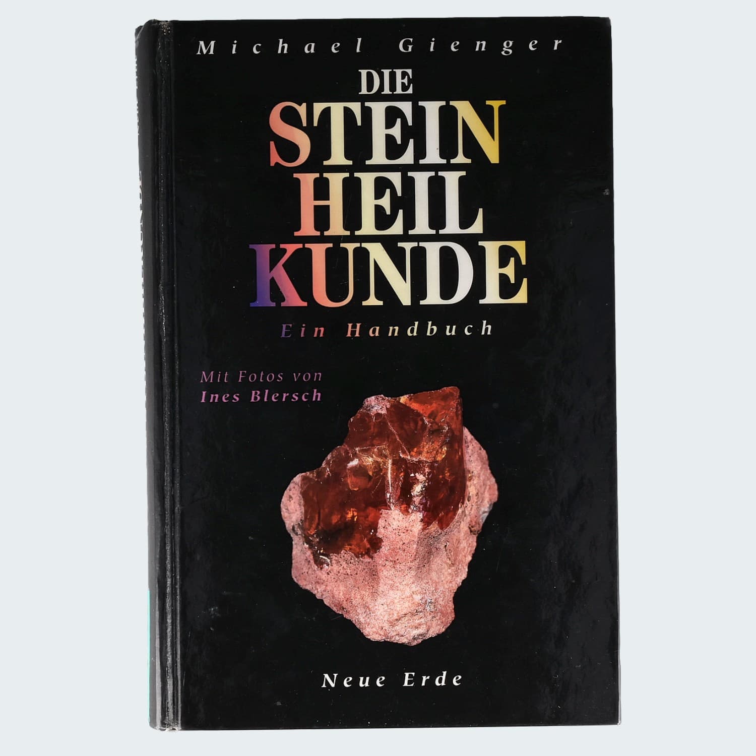 Michael Gienger, Die Steinheilkunde – Ein Handbuch – schwarze Vorderseite mit rotem Kristall auf Muttergestein